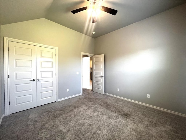 unfurnished bedroom featuring carpet, lofted ceiling, baseboards, a closet, and a ceiling fan