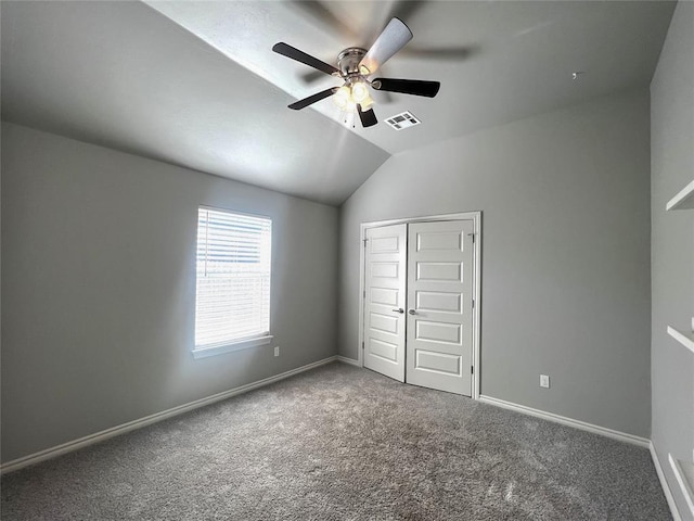 unfurnished bedroom with carpet, lofted ceiling, a closet, baseboards, and a ceiling fan