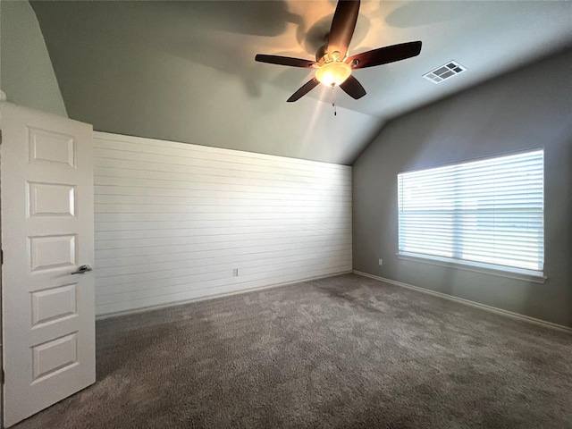 carpeted spare room featuring lofted ceiling, a ceiling fan, and baseboards