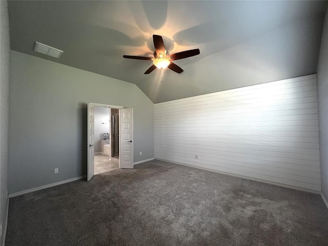 unfurnished bedroom with carpet flooring, lofted ceiling, ceiling fan, ensuite bathroom, and baseboards