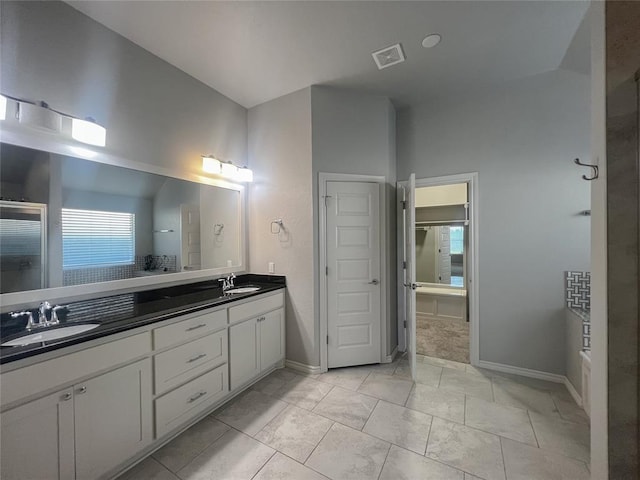 bathroom featuring double vanity, healthy amount of natural light, and baseboards