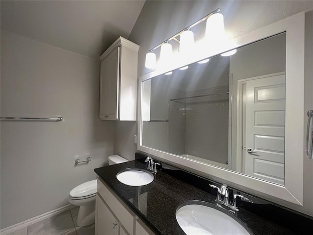 bathroom featuring toilet, double vanity, tile patterned flooring, and baseboards