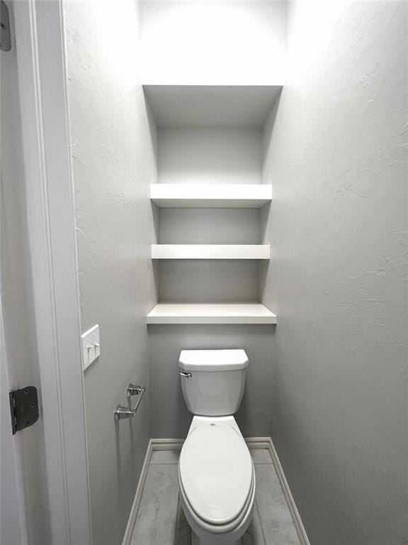 bathroom featuring baseboards and toilet