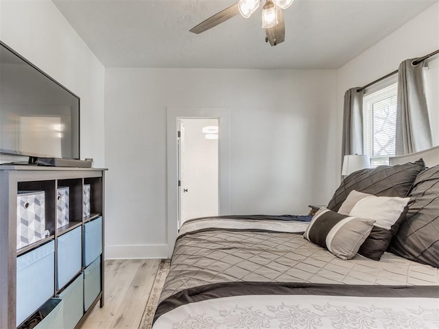 bedroom with baseboards, light wood-style floors, and ceiling fan