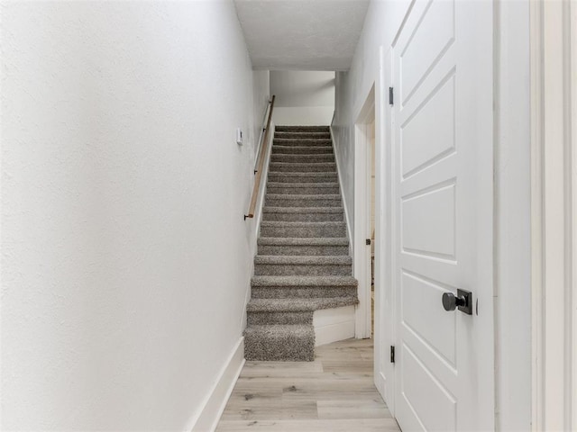 stairs with baseboards and wood finished floors