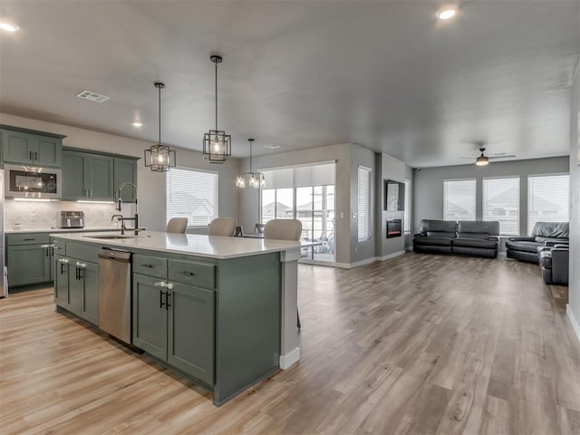 8129 NW 153rd St, Edmond, OK 73013 - kitchen featuring a sink, appliances with stainless steel finishes, green cabinetry, light countertops, and a ceiling fan