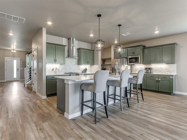 8129 NW 153rd St, Edmond, OK 73013 - kitchen with green cabinets, wall chimney exhaust hood, stainless steel microwave, light countertops, and recessed lighting