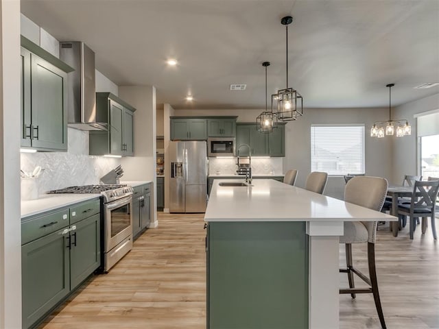8129 NW 153rd St, Edmond, OK 73013 - kitchen featuring stainless steel appliances, green cabinets, wall chimney exhaust hood, a sink, and recessed lighting