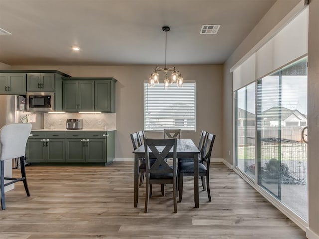 8129 NW 153rd St, Edmond, OK 73013 - dining room featuring a chandelier, light wood-style floors, and baseboards