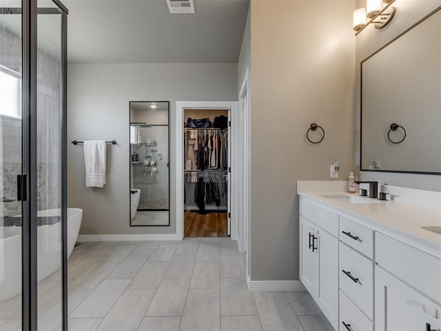 8129 NW 153rd St, Edmond, OK 73013 - full bath featuring a shower stall, double vanity, a spacious closet, a freestanding bath, and baseboards