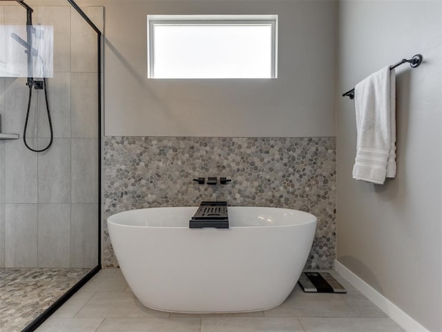 8129 NW 153rd St, Edmond, OK 73013 - full bathroom featuring a soaking tub, tile patterned floors, tiled shower, tile walls, and a wainscoted wall
