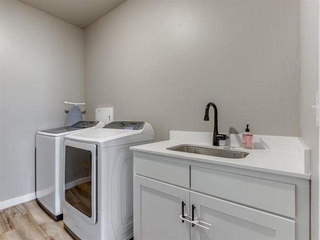 8129 NW 153rd St, Edmond, OK 73013 - washroom featuring washer and clothes dryer, cabinet space, and light wood-style floors