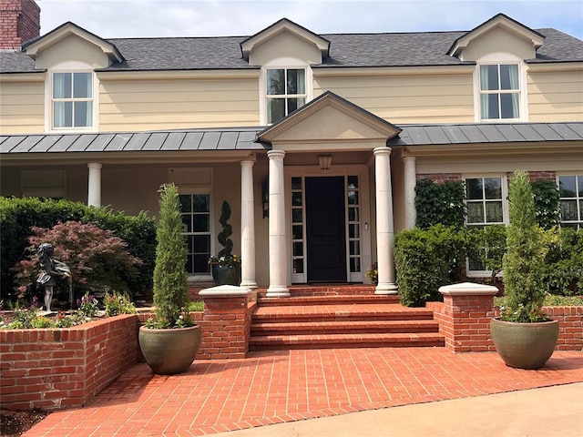 6802 NW Grand Blvd, Nichols Hills, OK 73116 - view of exterior entry with a standing seam roof, metal roof, and roof with shingles