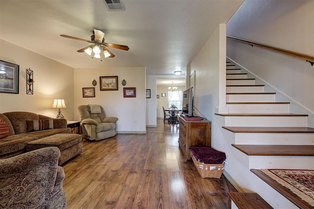 9122 Ns 3540th Rd, Prague, OK 74864 - living room with stairway, ceiling fan with notable chandelier, baseboards, visible vents, and wood finished floors