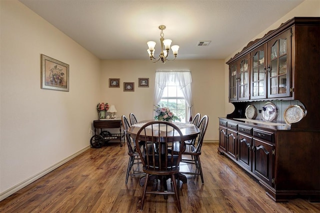 9122 Ns 3540th Rd, Prague, OK 74864 - dining area featuring dark wood finished floors, a notable chandelier, baseboards, and visible vents