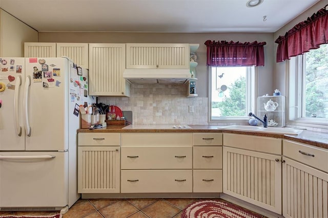 9122 Ns 3540th Rd, Prague, OK 74864 - kitchen with cream cabinets, a sink, under cabinet range hood, and white appliances