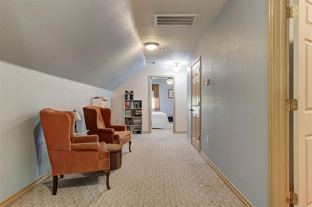9122 Ns 3540th Rd, Prague, OK 74864 - living area featuring vaulted ceiling, a textured ceiling, light colored carpet, visible vents, and a textured wall