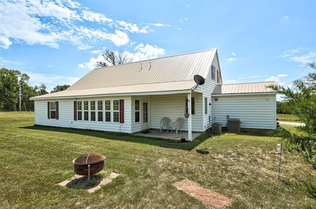 9122 Ns 3540th Rd, Prague, OK 74864 - back of property featuring metal roof, central AC unit, an outdoor fire pit, a yard, and a patio area