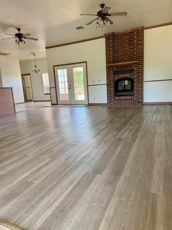 817 SW 16th St, Newcastle, OK 73065 - unfurnished living room featuring a ceiling fan, wood finished floors, french doors, a brick fireplace, and ornamental molding