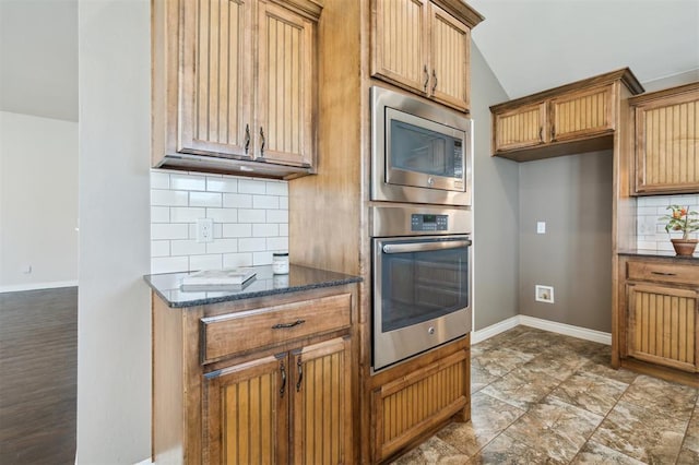 708 Havasu Dr, Norman, OK 73071 - kitchen with appliances with stainless steel finishes, decorative backsplash, baseboards, dark stone countertops, and lofted ceiling