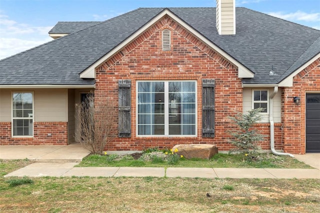 3311 Terrace Hills Rd, Piedmont, OK 73078 - view of front of house featuring brick siding, an attached garage, roof with shingles, and a chimney