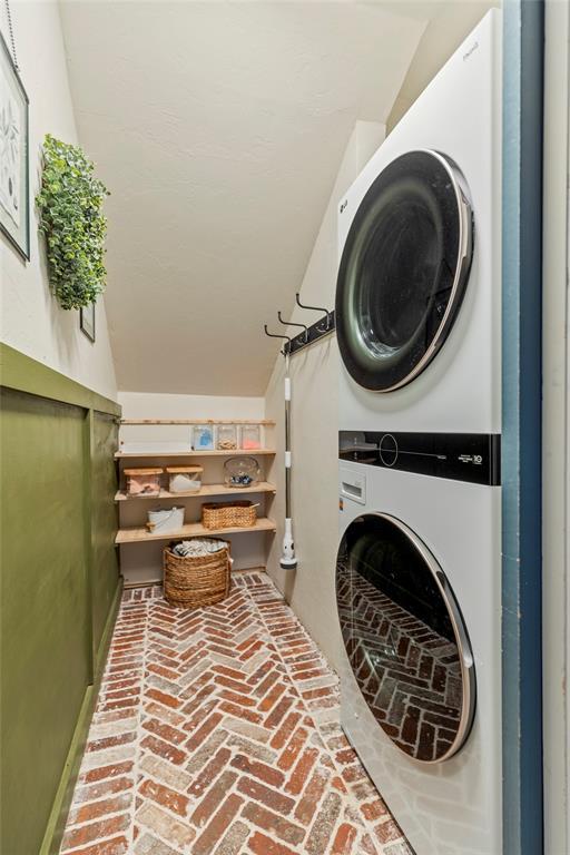 3311 Terrace Hills Rd, Piedmont, OK 73078 - clothes washing area with brick floor, stacked washer / drying machine, and laundry area