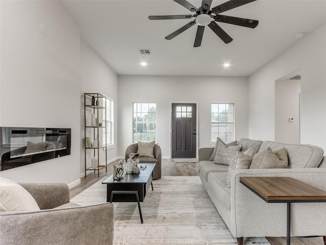 3100 NE 17th St, Oklahoma City, OK 73121 - living area with light wood-style flooring, ceiling fan, a glass covered fireplace, recessed lighting, and baseboards