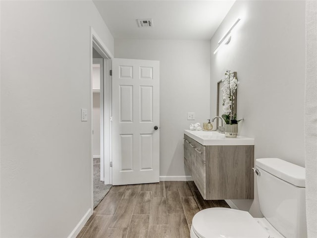 3100 NE 17th St, Oklahoma City, OK 73121 - half bathroom featuring toilet, wood finished floors, vanity, and baseboards