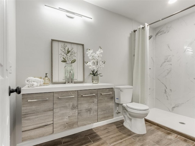 3100 NE 17th St, Oklahoma City, OK 73121 - full bathroom featuring toilet, vanity, a stall shower, wood tiled floors, and baseboards