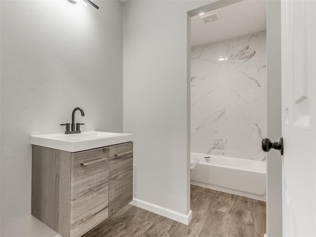 3100 NE 17th St, Oklahoma City, OK 73121 - bathroom with wood tiled floors, vanity, and bathtub / shower combination