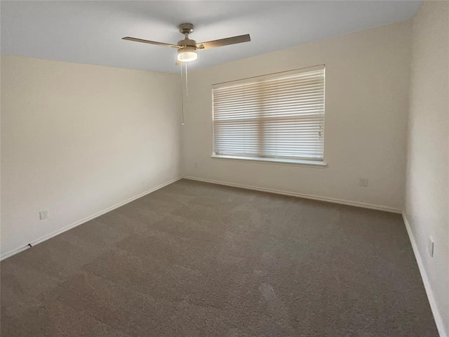 spare room featuring baseboards, carpet, and a ceiling fan