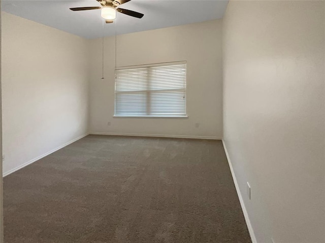 carpeted spare room with baseboards and ceiling fan