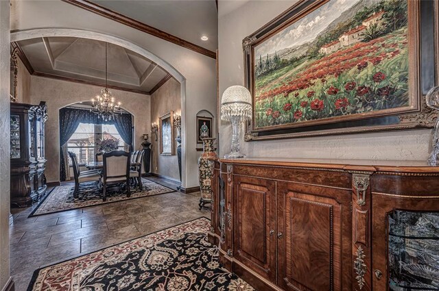 8301 NW 146th St, Oklahoma City, OK 73142 - entrance foyer featuring crown molding, arched walkways, stone tile floors, and an inviting chandelier