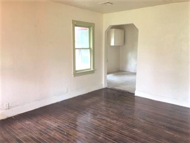2921 NW 12th St, Oklahoma City, OK 73107 - empty room featuring arched walkways, baseboards, and wood finished floors