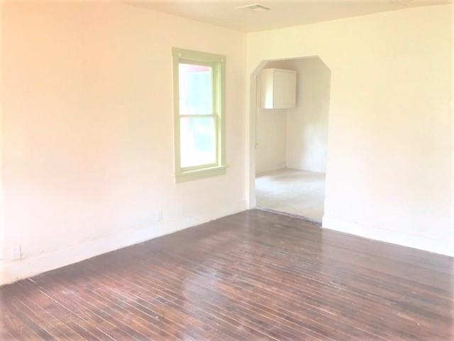2921 NW 12th St, Oklahoma City, OK 73107 - unfurnished room with arched walkways, baseboards, and wood finished floors