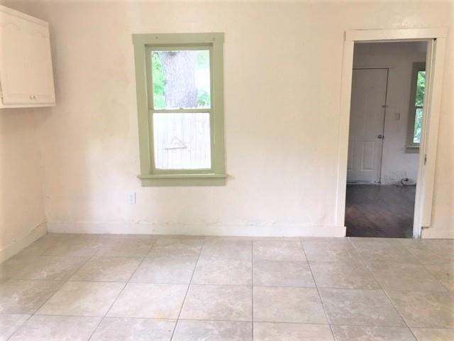 2921 NW 12th St, Oklahoma City, OK 73107 - spare room with baseboards and light tile patterned floors