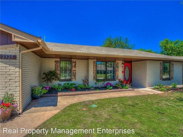 2325 NW 119th St, Oklahoma City, OK 73120 - property entrance featuring brick siding and a lawn