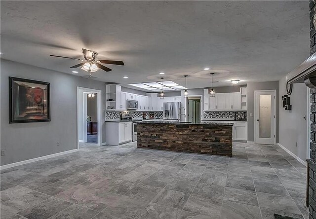 2325 NW 119th St, Oklahoma City, OK 73120 - kitchen featuring ceiling fan, dark countertops, appliances with stainless steel finishes, white cabinetry, and open shelves