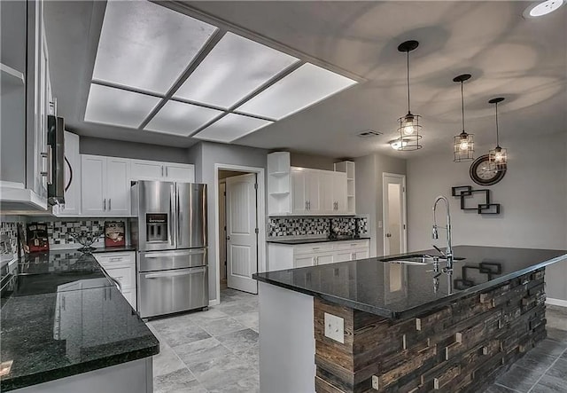 2325 NW 119th St, Oklahoma City, OK 73120 - kitchen featuring tasteful backsplash, appliances with stainless steel finishes, an island with sink, a sink, and open shelves