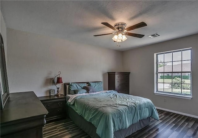2325 NW 119th St, Oklahoma City, OK 73120 - bedroom featuring dark wood-type flooring, baseboards, a textured ceiling, visible vents, and a ceiling fan