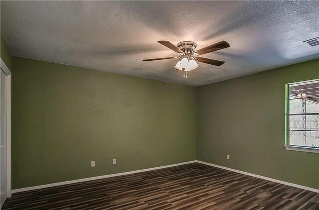 2325 NW 119th St, Oklahoma City, OK 73120 - unfurnished room featuring a textured ceiling, dark wood finished floors, baseboards, visible vents, and ceiling fan