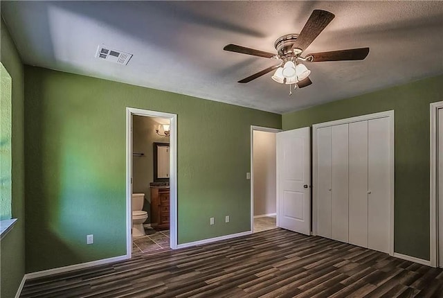 2325 NW 119th St, Oklahoma City, OK 73120 - unfurnished bedroom featuring dark wood finished floors, ensuite bathroom, baseboards, visible vents, and ceiling fan