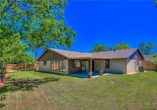 2325 NW 119th St, Oklahoma City, OK 73120 - rear view of house featuring cooling unit, fence, a patio, brick siding, and a yard