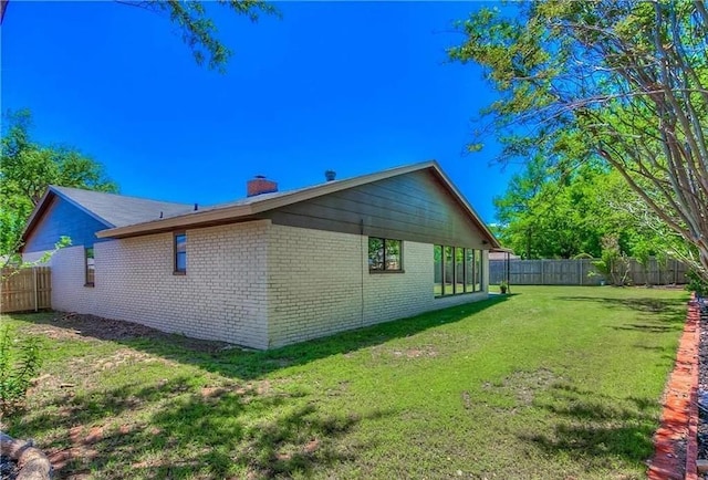 2325 NW 119th St, Oklahoma City, OK 73120 - view of side of home featuring a fenced backyard, a lawn, a chimney, and brick siding