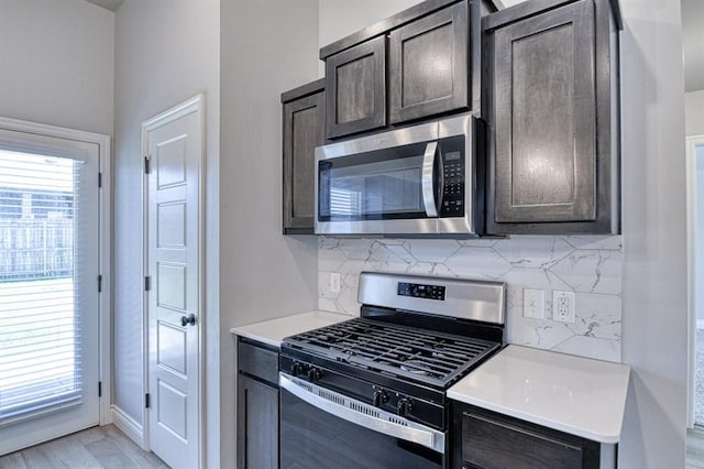 13412 Arrowhead Blvd, Yukon, OK 73099 - kitchen with stainless steel appliances, dark brown cabinetry, backsplash, light countertops, and light wood-style floors