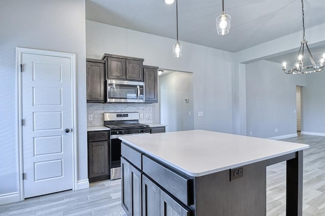 13412 Arrowhead Blvd, Yukon, OK 73099 - kitchen with light wood-style floors, backsplash, light countertops, appliances with stainless steel finishes, and a chandelier