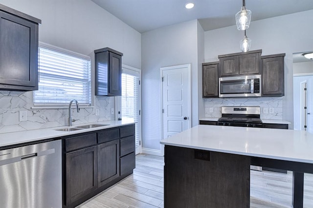 13412 Arrowhead Blvd, Yukon, OK 73099 - kitchen featuring a sink, stainless steel appliances, decorative light fixtures, and light countertops