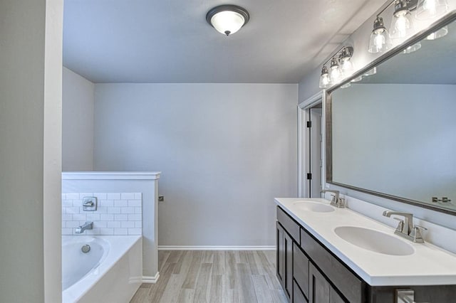 13412 Arrowhead Blvd, Yukon, OK 73099 - bathroom with a sink, double vanity, a garden tub, and wood finished floors