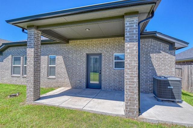 13412 Arrowhead Blvd, Yukon, OK 73099 - rear view of property with brick siding, a patio area, fence, and central AC