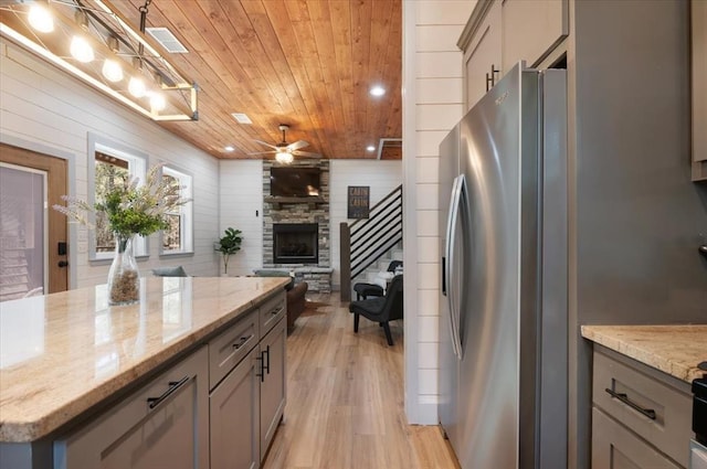 203 Secluded Cir, Broken Bow, OK 74728 - kitchen with stainless steel fridge, wood ceiling, gray cabinetry, light wood-style floors, and wood walls